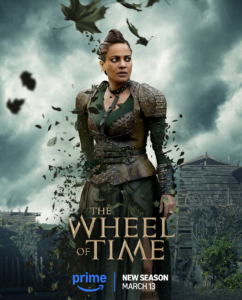 EXCLUSIVE: “The Wheel Of Time” Costume Designer Sharon Gilham Talks Season 3 7 Poster of Priyanka Bose as Alanna Mosvani. She has dark hair pulled back in braids. She wears brown leather armor with a collar over a dark green dress with thigh-high slits. Her body and clothes are dissolving into leaves. Text reads “The Wheel Of Time: New Season, March 13th”.